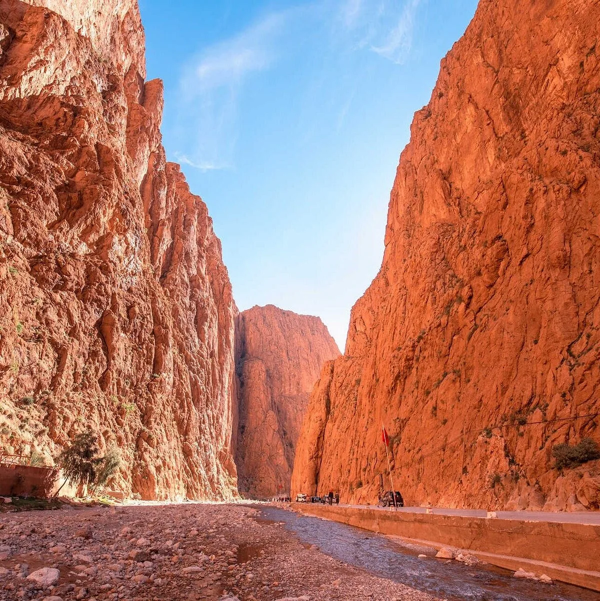 Tissadrine & Nomadic Landscapes: road and riverbed framed by tall red-orange walls of dades gorge