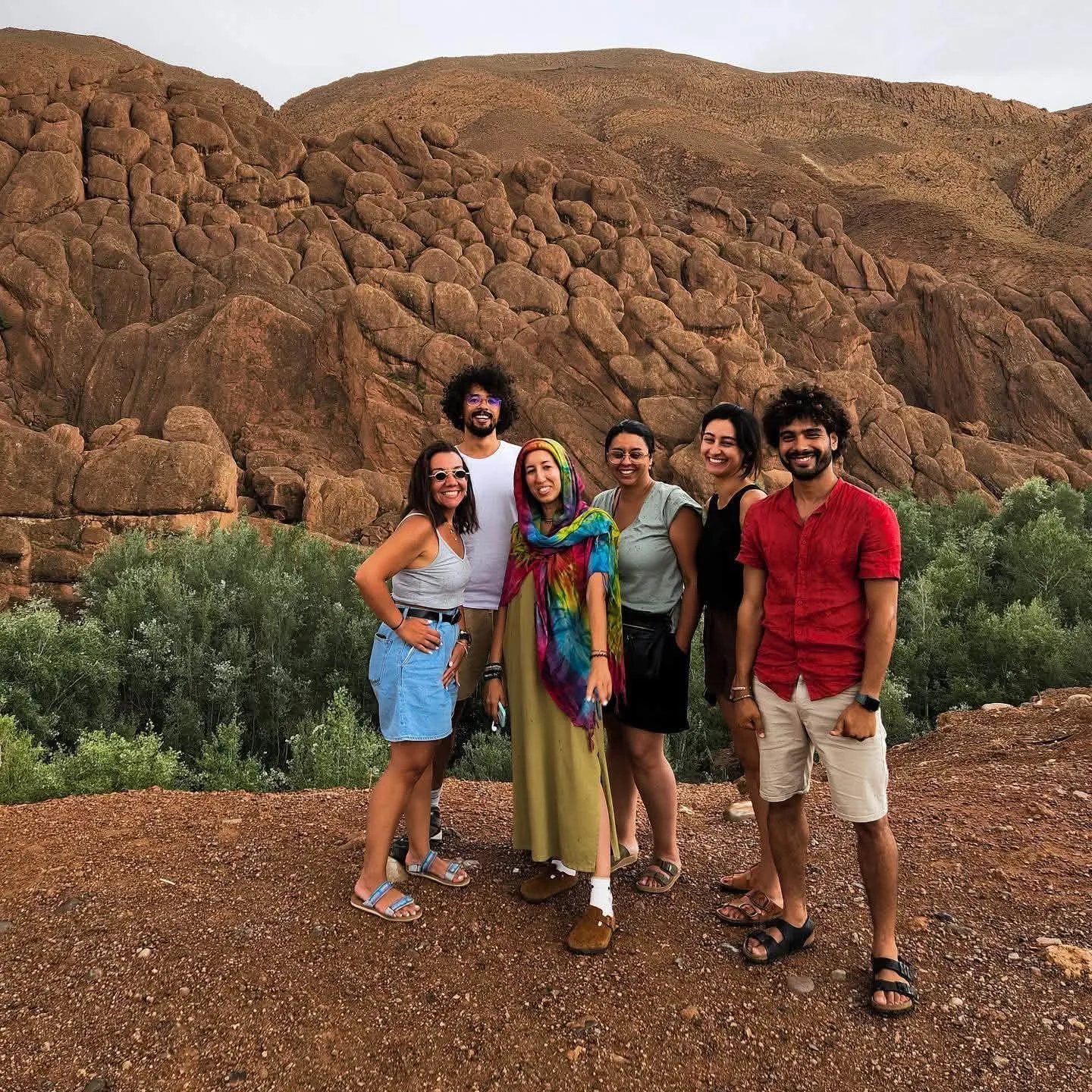 Local Dades guide with travellers in front of rounded ochre rock formations