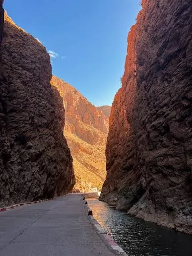 Narrow road and stream passing between steep Dades canyon walls